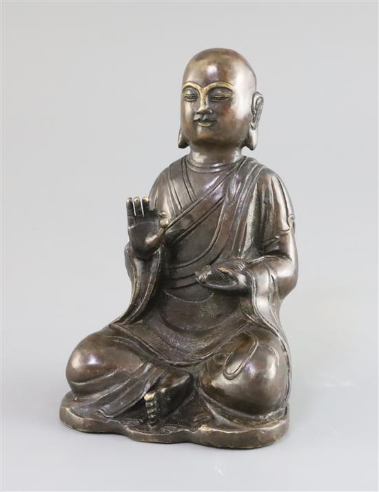 A Chinese bronze figure of a seated Luohan, 17th/18th century, H. 16cm